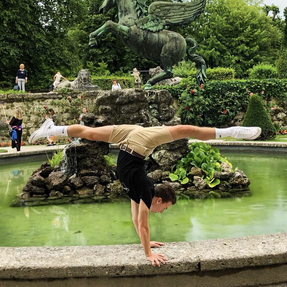 Musical Theater Studio student doing a handstand split at a fountain in Salzburg