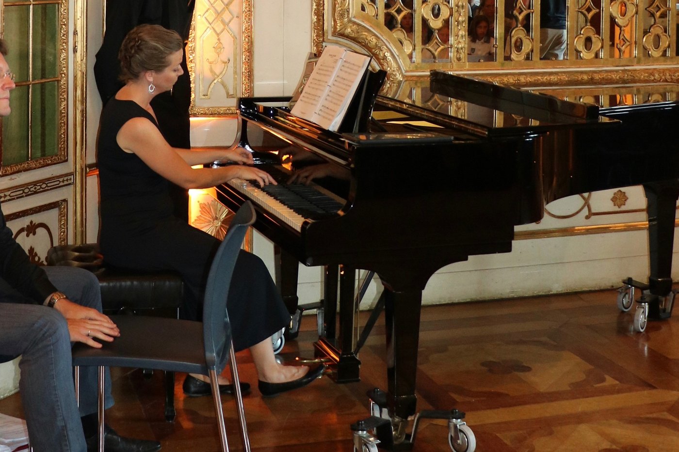 MTB collaborative pianist performing at a grand piano in an ornate gilded hall